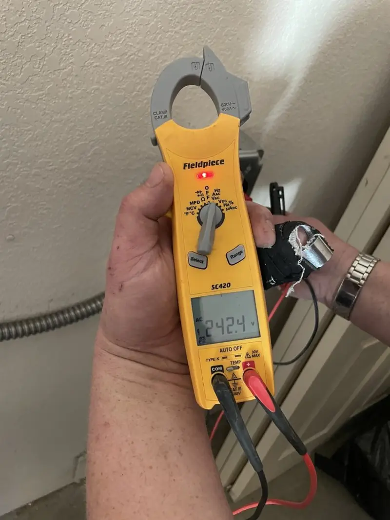 Voltage testing with clamp meter during Ceiling Fan Installation in Bath